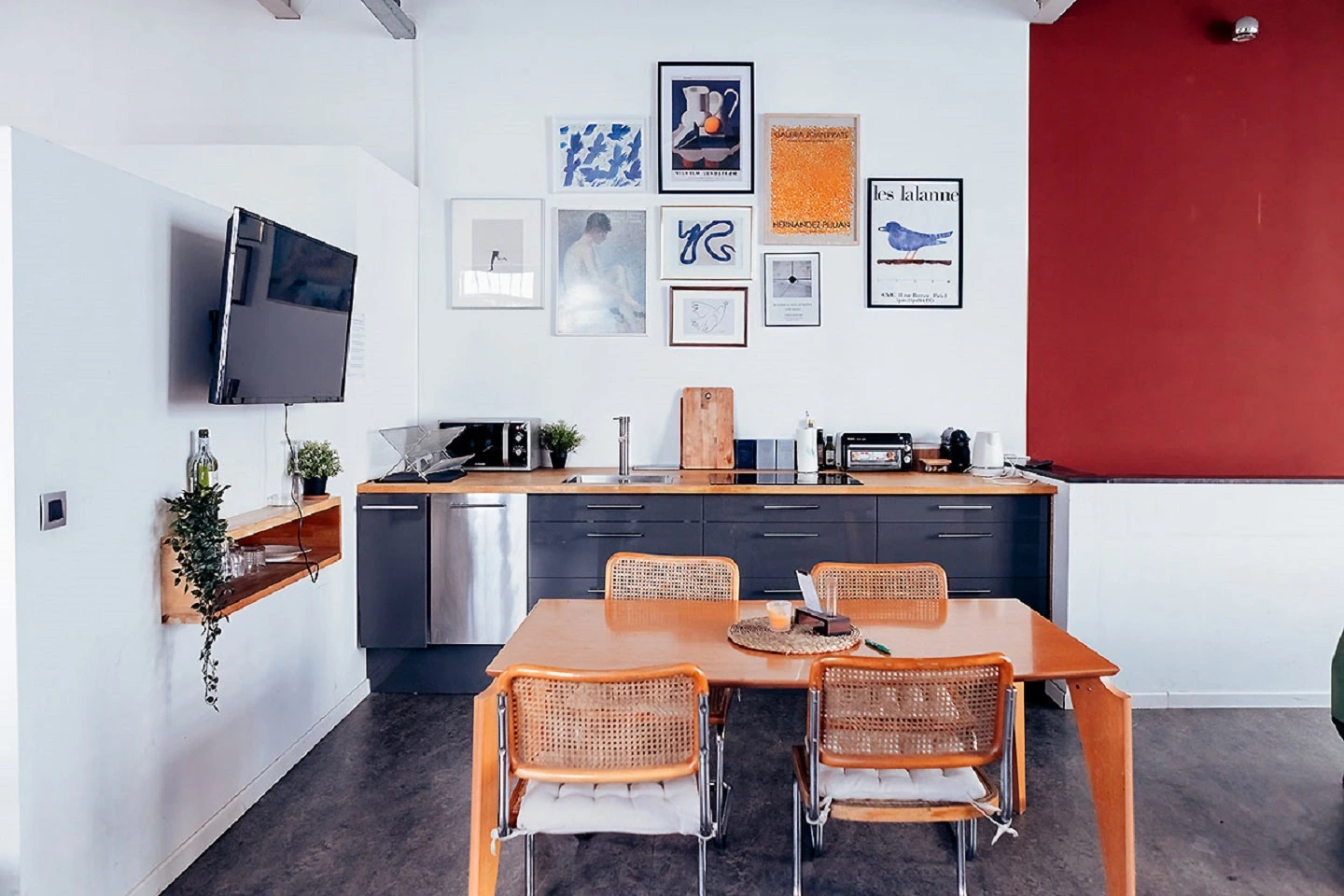 a fully-equipped modern kitchen with a table, chairs, microwave